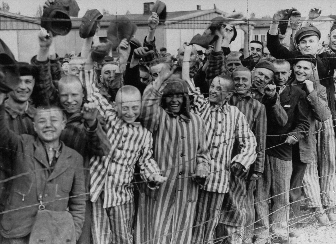 Prisioneros supervivientes de Dachau saludan a los soldados estadounidenses, abril de 1945.